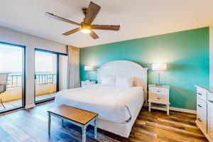 a bedroom with a bed and a ceiling fan at Surf Dweller 203 in Fort Walton Beach +17 photos