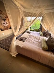 um quarto com uma cama com uma imagem de leão na parede em Jackals Dream - Self Catering Villa bordering Kruger National Park em Marloth Park