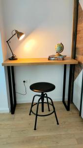 a desk with a stool and a desk with a lamp at Oak Apartment lovely one bedroom apartment at Columna Residence near Vivo mall in Cluj-Napoca