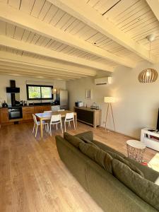 ein Wohnzimmer mit einem Sofa und einem Tisch in der Unterkunft La Halte Occitane - Logement neuf 6 personnes 3 chambres tout confort in Montauban