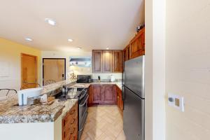 a kitchen with wooden cabinets and a stainless steel refrigerator at Simba Run, Unit 1510 in Vail