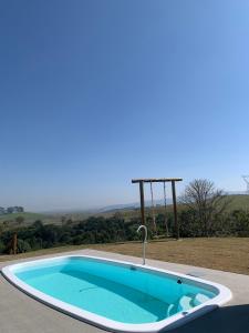 a large swimming pool with a faucet in a yard at Recanto Sol Poente in Caçapava