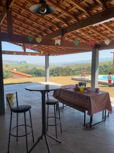 een tafel en twee stoelen in een kamer met uitzicht bij Recanto Sol Poente in Caçapava
