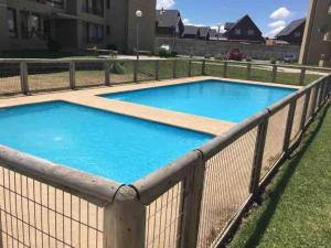 a swimming pool with a fence around it at Bello depto full equipado in Los Ángeles +3 photos