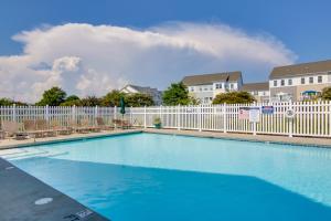 a swimming pool with chairs and a white fence at Luxury Ocean City Retreat with Beautiful Bay Views in Ocean City