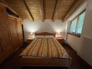 a bedroom with a large bed with two lamps on tables at Appartamenti Castagner in Pinzolo