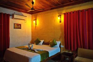 a bedroom with a bed with two towels on it at Resort Raktokorobi Karugram - Escape to Green Stay with Soul in Srī Niketan