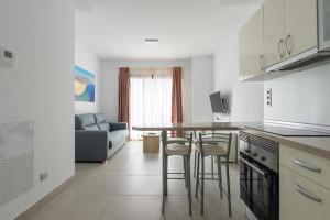 a kitchen with a table and chairs in a room at Canteras Suites in Las Palmas de Gran Canaria