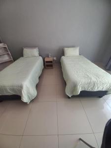 two beds sitting next to each other in a room at Rocky Hills Guesthouse in Piet Retief