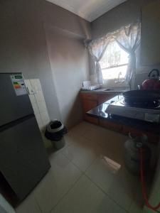 a small kitchen with a stove and a window at Rocky Hills Guesthouse in Piet Retief