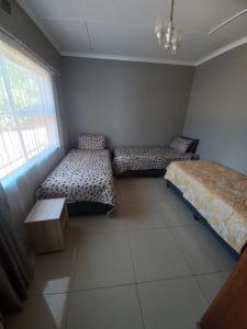 a room with two beds and a window at Rocky Hills Guesthouse in Piet Retief