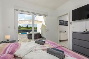 KršanにあるVilla Blue Lagoon - Private Pool and Whirlpoolのベッドルーム1室(大型ベッド1台、スライド式ガラスドア付) +28枚の写真