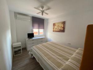 a bedroom with a bed and a ceiling fan at Vacaciones en familia o amigos in Málaga