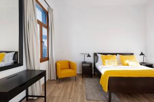 een slaapkamer met een bed en een gele stoel bij Casa Camino La Estrella in Breña Alta