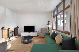 un soggiorno con divano verde e TV di Casa Camino La Estrella a Breña Alta