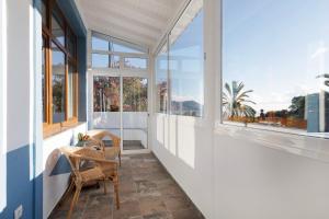 d'un balcon avec des fenêtres, une table et des chaises. dans l'établissement Casa Camino La Estrella, à Breña Alta