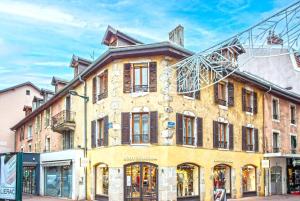 un gran edificio amarillo con una antena encima en Appartement centre-ville Annecy en Annecy