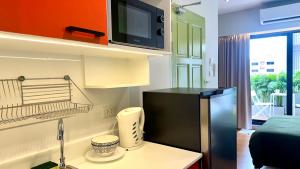 a small kitchen with a black refrigerator in a room at The Tangerine Guesthouse in Bangkok