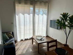 a living room with a table and a large window at Maisonnette avec petite forêt in Valréas