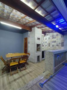a dining room with a table and a fireplace at Casa com Piscina Orla 500 Unamar Cabo Frio in Cabo Frio
