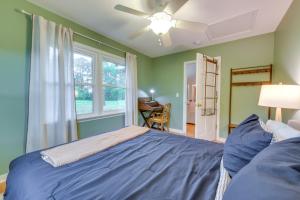 Un dormitorio con una cama azul y una ventana en Riverfront Virginia Home - Dock, Fire Pit and Kayaks, en Weems