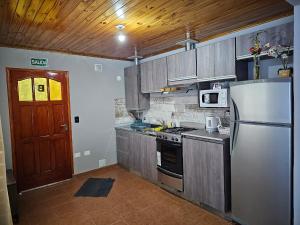 eine Küche mit einem Kühlschrank und einem Herd Top-Backofen in der Unterkunft La Herradura de Ushuaia in Ushuaia