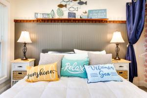 a bedroom with a bed with pillows on it at Cozy Cottage Minutes to Downtown Southport! in Southport