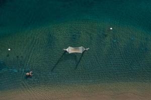 an aerial view of a beach with an umbrella in the water at Praia Art Resort - Small Luxury Hotels of the world in Le Castella