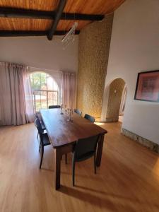 Cette grande chambre dispose d'une table et de chaises en bois. dans l'établissement 29B Zebra Street - InHimwe Guesthouse, à Polokwane