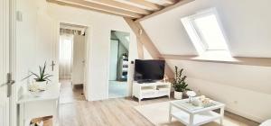 a white living room with a tv and a window at Ma Douce Bulle Piscine & Détente in Saint-Léger-près-Troyes