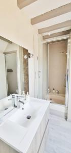 a white bathroom with a sink and a mirror at Ma Douce Bulle Piscine & Détente in Saint-Léger-près-Troyes