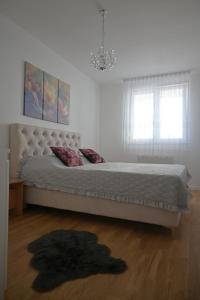 - une chambre blanche avec un grand lit et un mur blanc dans l'établissement SET apartment, à Sarajevo