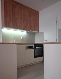 - une cuisine avec des appareils blancs et des armoires en bois dans l'établissement SET apartment, à Sarajevo