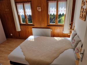 een slaapkamer met een bed in een kamer met ramen bij Chambres d'hôtes A la Fecht Nature et Bien-être in Sondernach