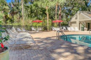 a pool with chairs and tables and umbrellas at Greens 198 in Hilton Head Island