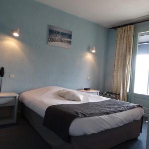 um quarto com uma cama grande e uma janela em Europa Hotel em Roussillon en Isere