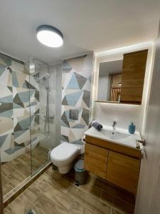 a bathroom with a toilet and a shower and a sink at Minimal Two-Floor Apartment in Thessaloniki