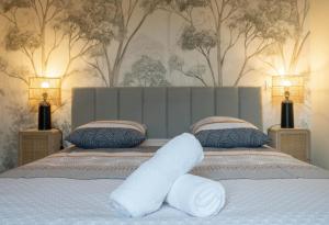 a bedroom with a bed with white sheets and two lamps at Le Royal - Appartement design - Hyper centre in Vichy