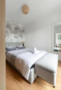 a white bedroom with a large bed with white sheets at Le Royal - Appartement design - Hyper centre in Vichy