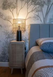 une lampe assise sur une table à côté d'un lit dans l'établissement Le Royal - Appartement design - Hyper centre, à Vichy