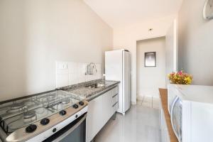 een keuken met een fornuis en een witte koelkast bij Apartamento Em Santo André 3 Quartos e Garagem | Camilópolis in Santo André