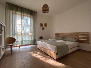 a bedroom with a bed and a chair and a window at Casa La Pigna in Pisa