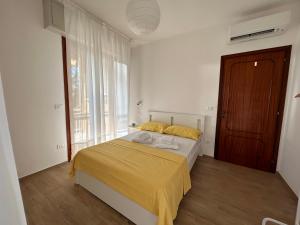 a bedroom with a bed with yellow sheets and a window at Casa La Pigna in Pisa
