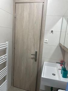 a bathroom with a wooden door next to a sink at Anastasia’s Home in Chania