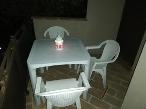 uma mesa branca e cadeiras com uma vela em Appartamenti Cardinali em Assisi