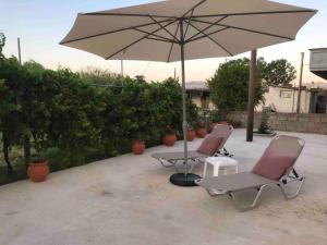 two chairs and a table with an umbrella at Anastasia’s Home in Chania