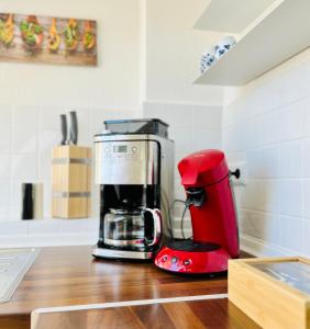 Una cafetera roja sentada en una encimera de cocina en AyCatcherHomes Top Lage charmante Atmosphäre in ruhiger Altstadt Marburgs Apartment Sirius, en Marburg an der Lahn