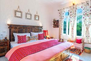 um quarto com uma cama grande e almofadas vermelhas em The Himaal, Bir - Boutique Homestay em Bir