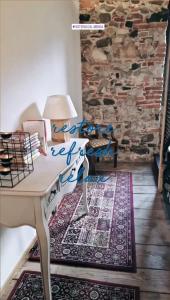 a room with a desk and a stone wall at Hotel Dal Menga in Torrebelvicino