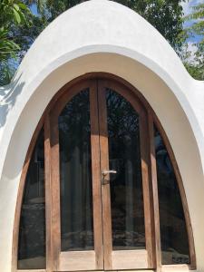 an arched window with a wooden door at Villa Hopedome in Teluk Nara